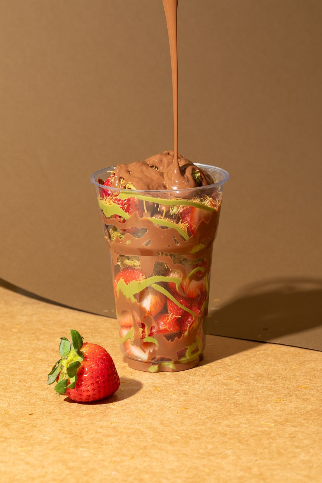 Chocolate pouring into a strawberry cup